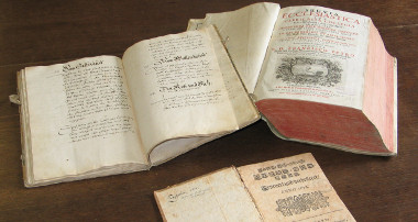 Bild: drei historische Bücher auf einem braunen Tisch