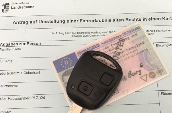 Autoschlüssel der auf einem Führerschein liegt. 